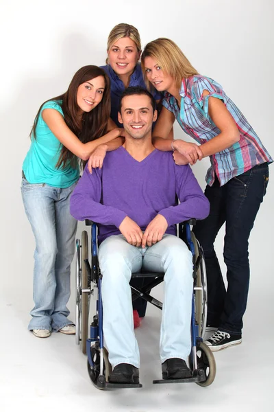 Молодий чоловік у інвалідному візку з групою подруг-дівчат — стокове фото