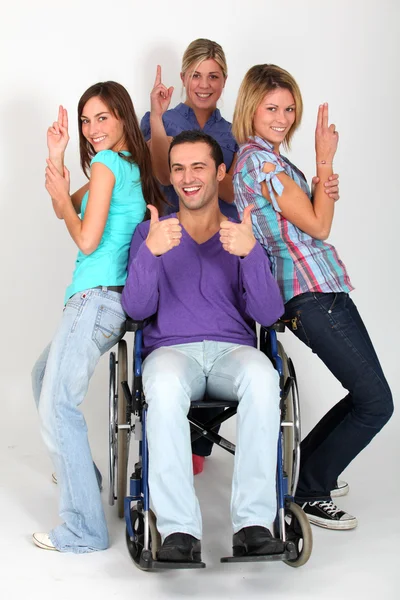 年轻男子坐在轮椅上与组女孩朋友 — 图库照片