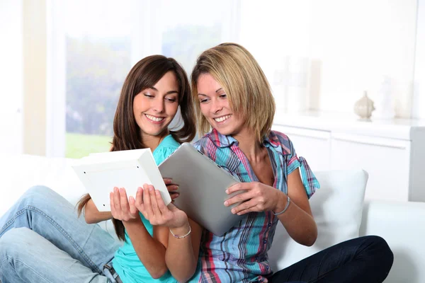 Flickvänner läsa bok på elektroniska pad — Stockfoto