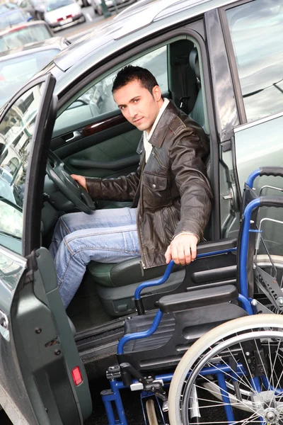 Young man in wheelchair getting in his car — Stock Photo, Image