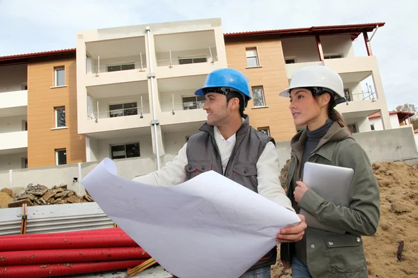 Arquiteto e engenheiro olhando para o plano no canteiro de obras — Fotografia de Stock