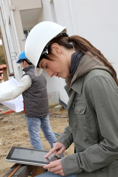 Ingenieurin mit weißem Schutzhelm steht auf Baustelle — Stockfoto