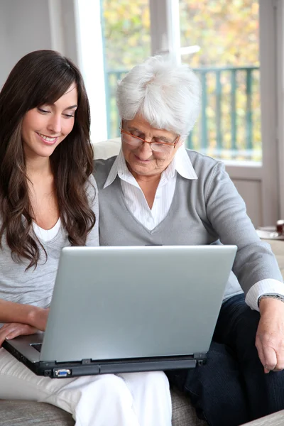 Young woman and elderly woman with laptop computer — Stock Photo, Image