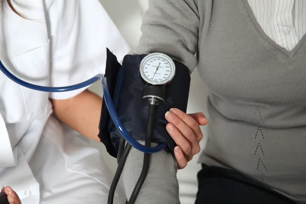 Closeup of nurse checking senior woman blood pressure — Stock Photo, Image