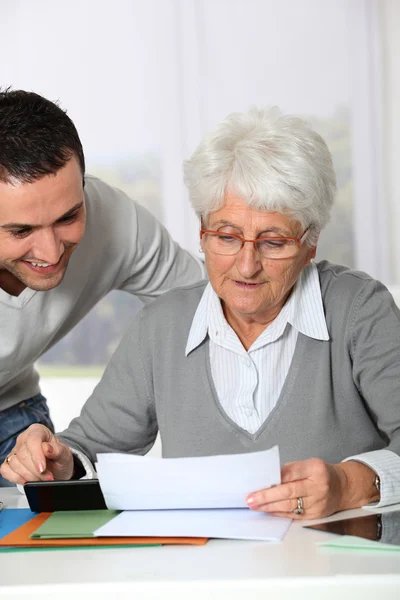 Joven ayudando a anciana con papeleo — Foto de Stock