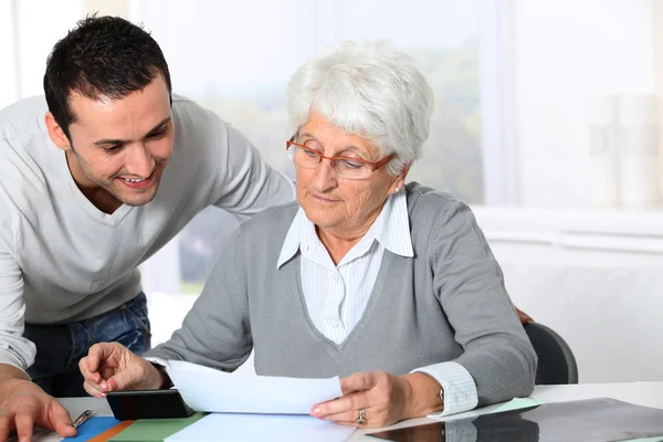 Joven ayudando a anciana con papeleo — Foto de Stock