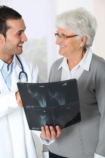 Doktor ukazuje x-ray výsledky starší žena — Stock fotografie