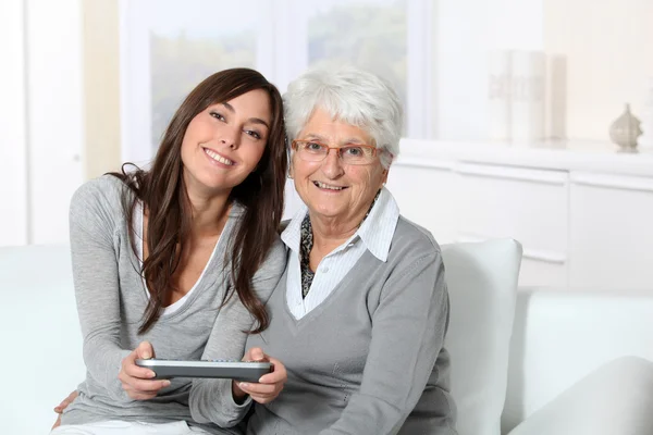 Mujer joven jugando videojuego con la abuela — Foto de Stock