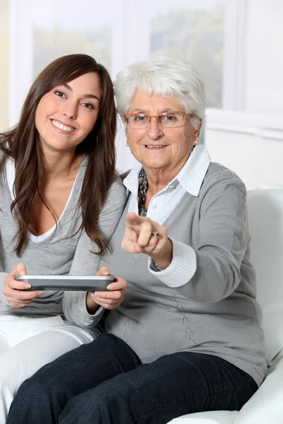 Mujer joven jugando videojuego con la abuela — Foto de Stock