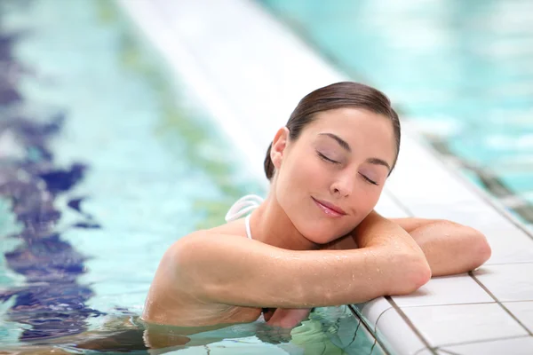 Beautiful young woman relaxing in seawater pool — Stock Photo, Image
