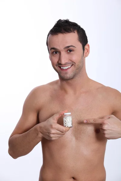 Smiling man holding bottle of pills — Stock Photo, Image