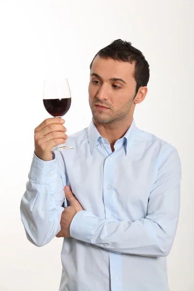 Young man on white background tasting red wine — Stock Photo, Image