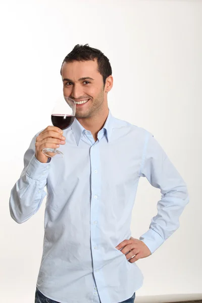 Jonge man op witte achtergrond rode wijn proeverij — Stockfoto