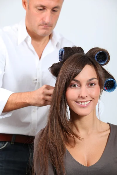 Woman getting hair-curlers Stock Picture