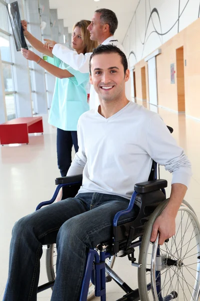 Медицинская команда с инвалидом смотрит на рентген Стоковое Фото