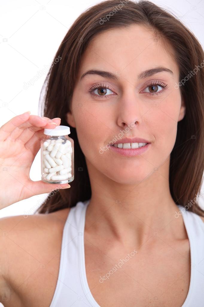 Closeup of woman holding bottle of pills
