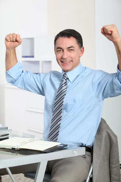 Muž v kanceláři ukazující pozitivity — Stock fotografie