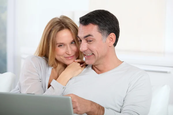 Pareja feliz navegando en internet en casa — Foto de Stock