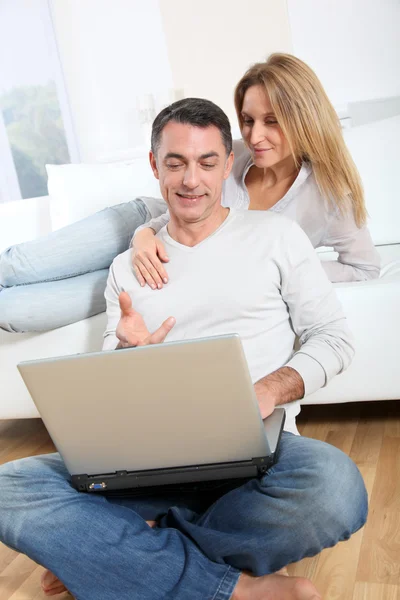 Feliz casal surfar na internet em casa — Fotografia de Stock