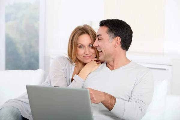 Feliz casal surfar na internet em casa Imagem De Stock