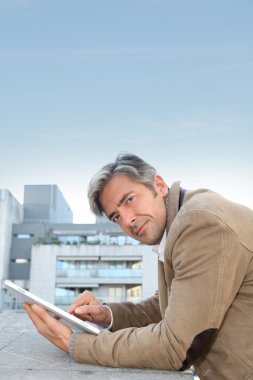 Elektronik tablet kullanarak şehirde yakışıklı adam