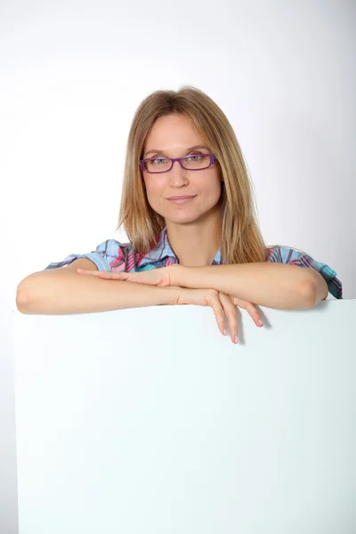 Blonde vrouw met glazen tonen whiteboard — Stockfoto