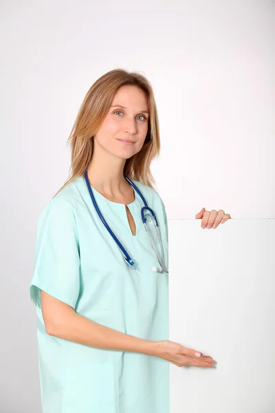 Mooie verpleegster bedrijf wit bord — Stockfoto
