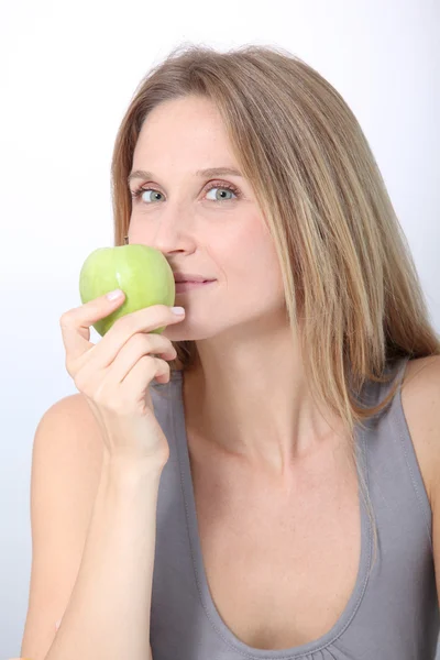 Bella donna bionda che mangia mela verde — Foto Stock