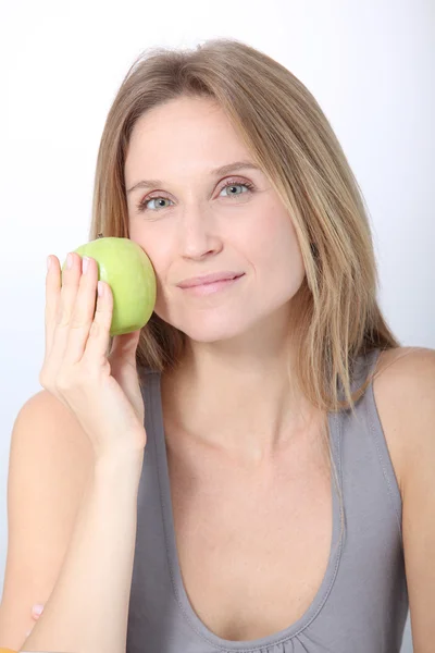 Bella donna bionda che mangia mela verde — Foto Stock