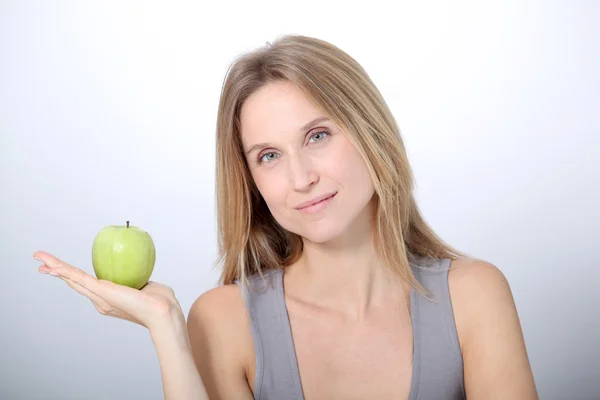 Mulher loira bonita comendo maçã verde — Fotografia de Stock