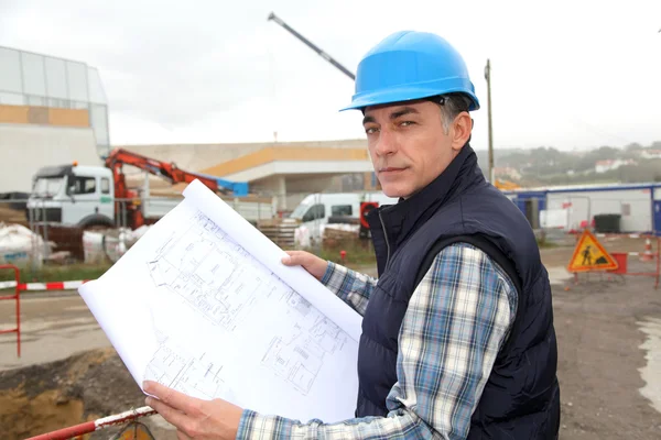 Ingeniero en obra con plano de construcción —  Fotos de Stock