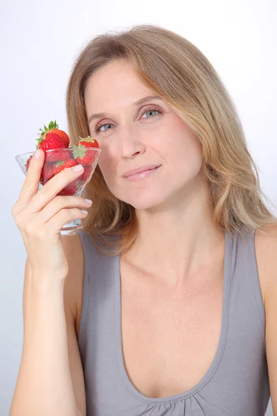 Mooie blonde vrouw eten aardbeien — Stockfoto