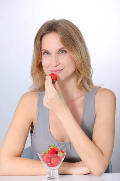Krásná blonďatá žena jíst jahody — Stock fotografie