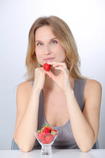 Mooie blonde vrouw eten aardbeien — Stockfoto