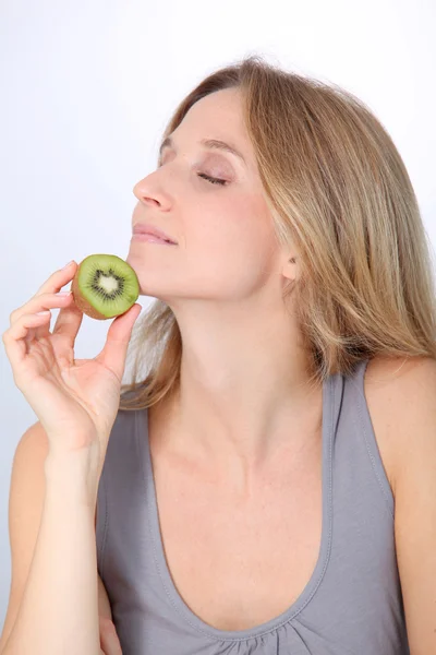 Bella donna bionda che mangia kiwi — Foto Stock