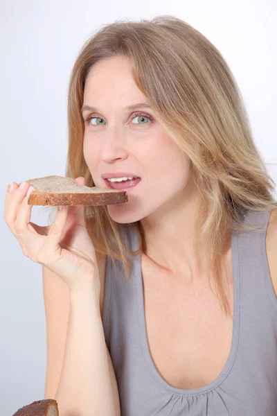 Close-up van mooie vrouw sneetje brood eten — Stockfoto