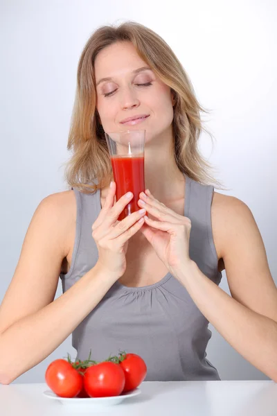 Mulher bebendo suco de tomate — Fotografia de Stock