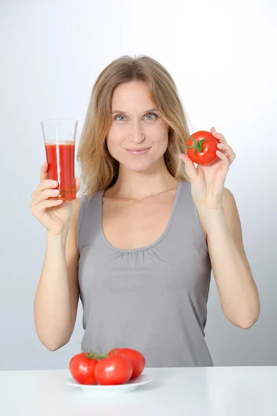 Vrouw die tomatensap drinkt — Stockfoto