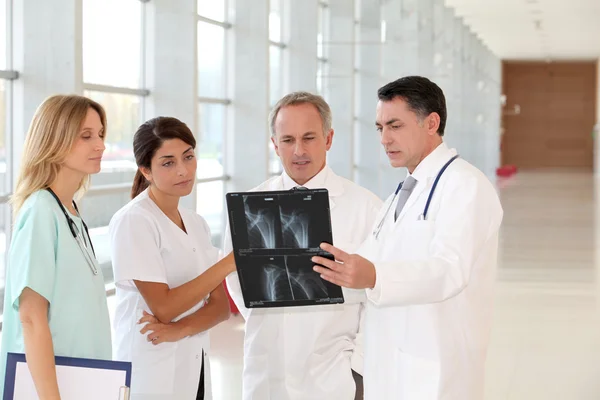 Grupo de médicos y enfermeras mirando rayos X — Foto de Stock