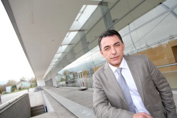 Businessman standing outside modern building — Stock Photo, Image