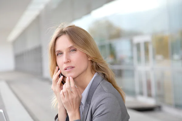 Kobieta na telefon przed nowoczesnym budynku — Zdjęcie stockowe