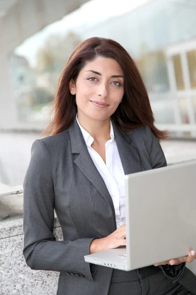 Zakenvrouw met laptop computer staan buiten — Stockfoto