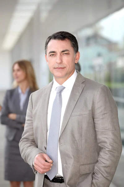 Businessman standing outside modern building — Stock Photo, Image