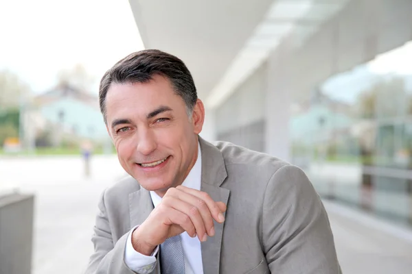 Businessman standing outside modern building — Stock Photo, Image