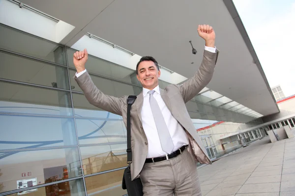 Lachende zakenman met armen omhoog — Stockfoto