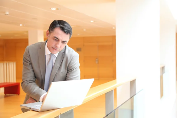 Zakenman met laptopcomputer te wachten in de hal — Stockfoto