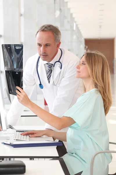 Médico y enfermera mirando rayos X — Foto de Stock