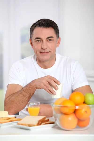 Sorrindo homem adulto tomando café da manhã — Fotografia de Stock