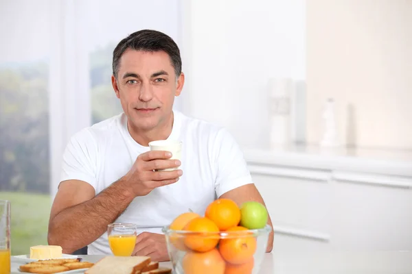 Smiling adult man having breakfast — Stock Photo, Image