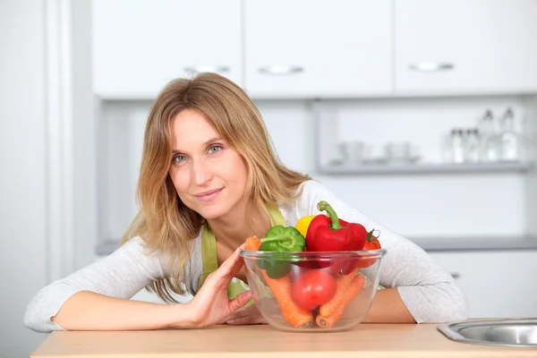 Woman in kitchen ready to prepare meal with vegetables — Stock Photo, Image
